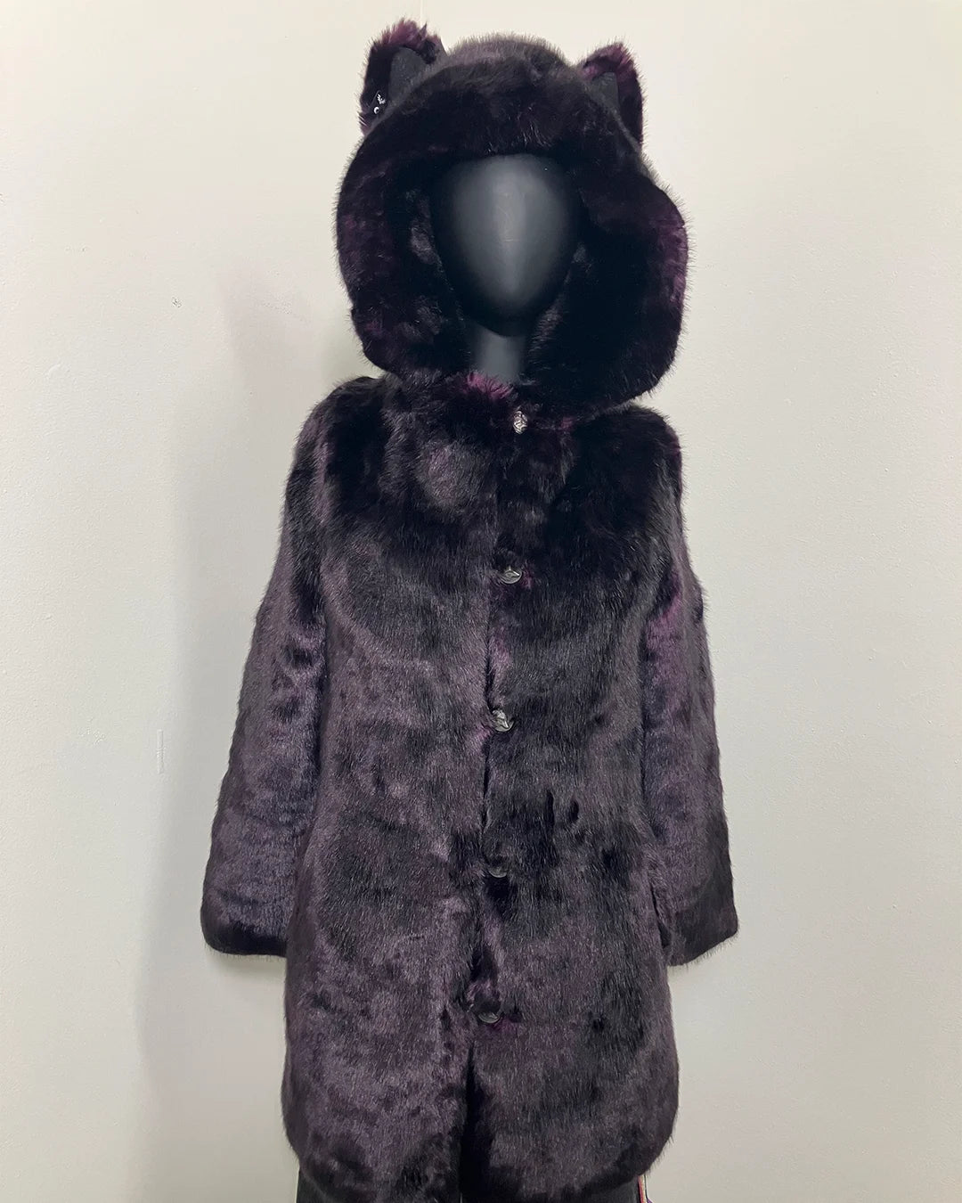 Purple fake fur coat with hood and wolf ears on a mannequin against a white background