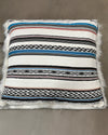 Decorative pillow with striped baja pattern on a neutral background