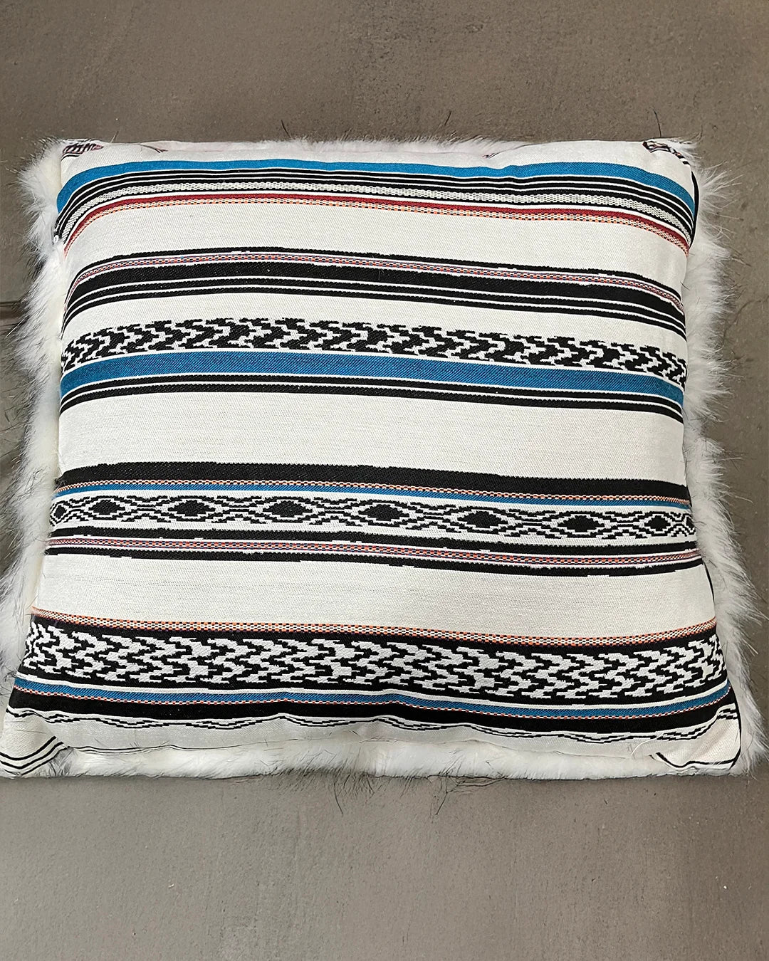 Decorative pillow with striped baja pattern on a neutral background