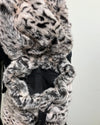 Close-up of a fake fur backpack and the inner pocket with a white tiger pattern on a plain background