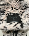 Close-up of a faux fur backpack with a brand SpiritHoods logo faux-leather label featuring a white tiger design.
