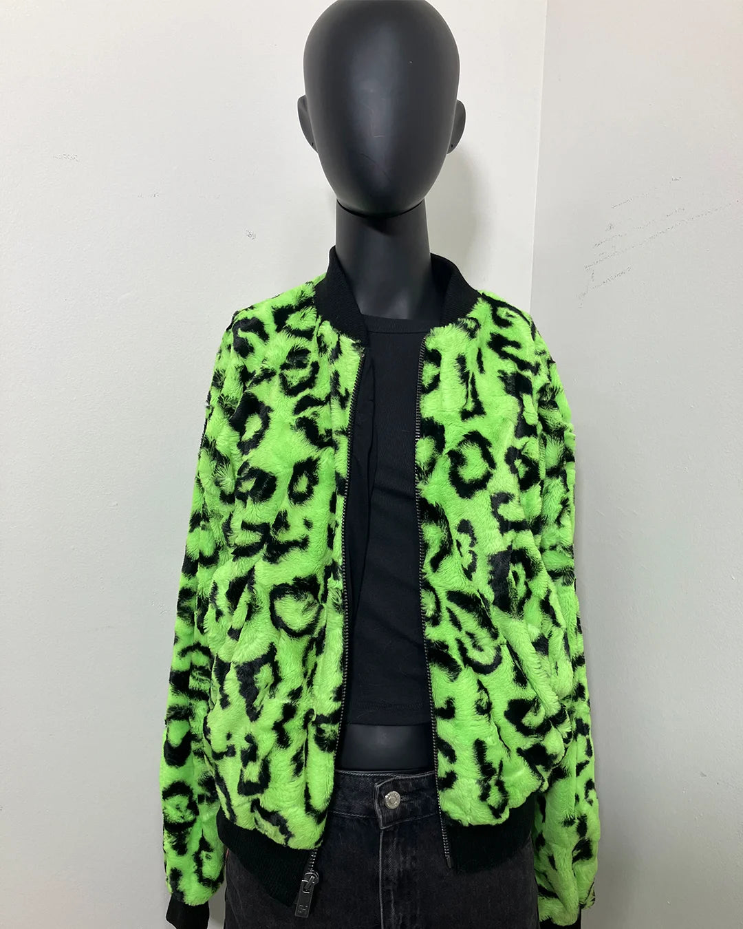 Mannequin wearing a neon green leopard print short pile fake fur jacket against a white background