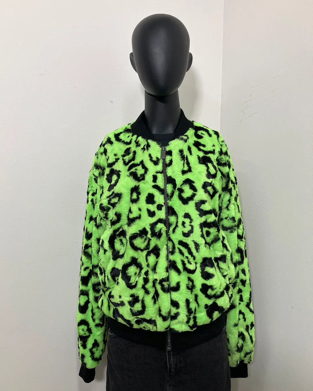 Neon green leopard print short pile faux fur jacket on a mannequin against a white background
