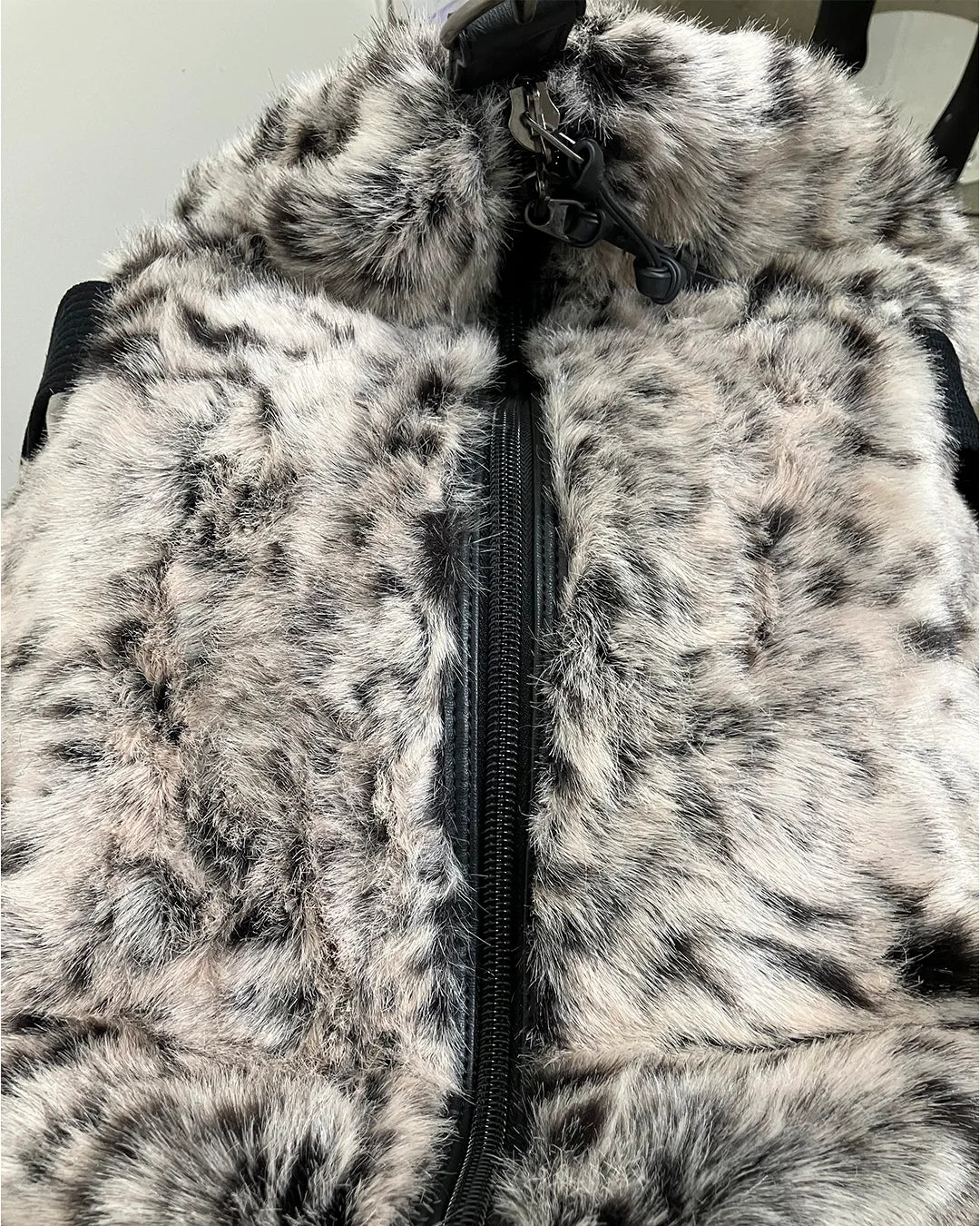 Close-up of a white tiger fake fur duffle bag with a zipper, showing texture and pattern.