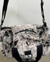faux fur duffle bag with black straps on a neutral background