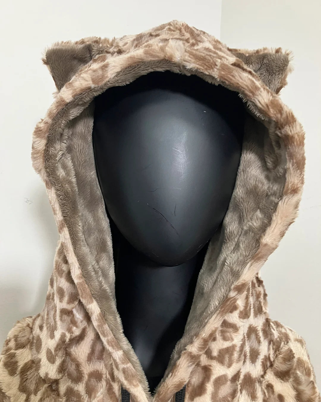black mannequin wearing a tan leopard print hoodie with a hood and kitty ears on the top
