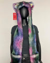 A multicolor faux fur scarf with integrated cat ears and a matching collar, displayed on a black mannequin torso. The scarf features a vibrant tie-dye pattern of purple, pink, green, and blue.