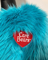 Turquoise fluffy fabric with a red 'Care Bears' patch