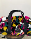 Multicolored fluffy bag with a visible brand logo on a neutral background
