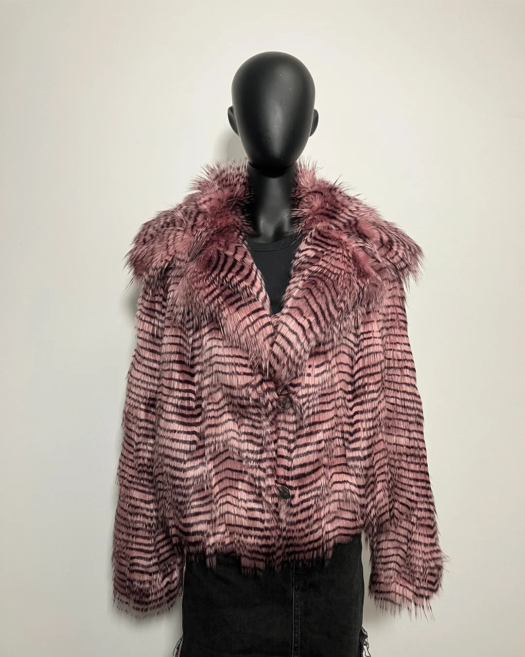 Mannequin wearing a pink and purple patterned faux fur jacket against a plain background
