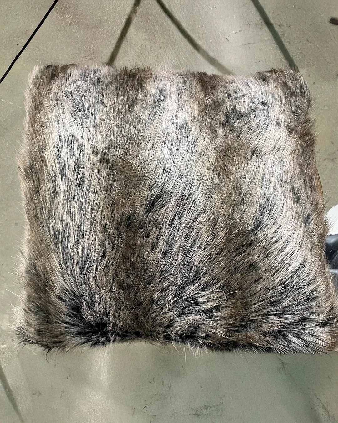 Fake Fur-patterned pillow on a concrete surface