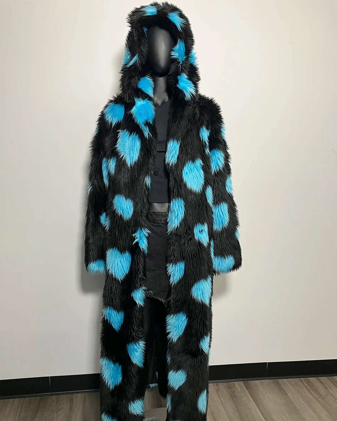 Mannequin wearing a black and blue polka dot fur coat against a plain background