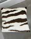 Zebra-striped pillow on a gray surface