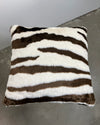 brown zebra with brown and white faux fur pattern on a gray floor.