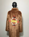 Brown faux fur coat with colorful geometric patterns on a mannequin against a white background