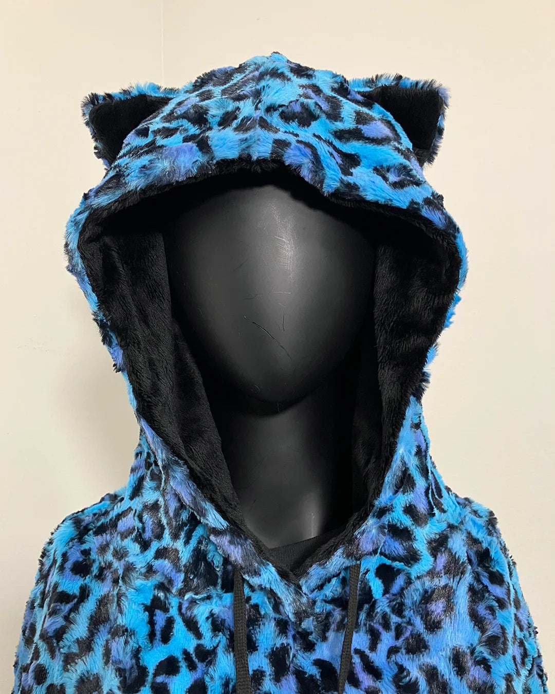 Blue leopard print hoodie with black ears on a beige background