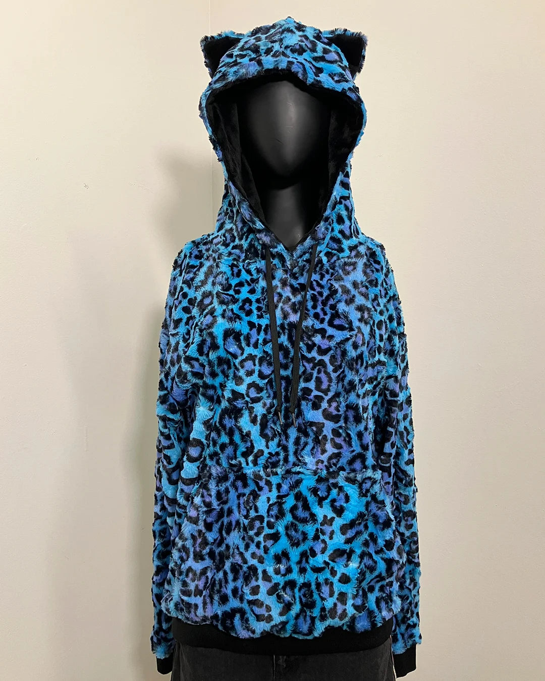 Blue leopard print hoodie with cat ears on a mannequin against a beige background