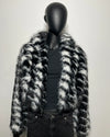 Mannequin wearing a black and white fake fur coat against a plain background