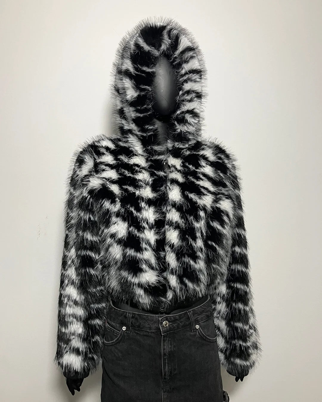 Black and white fake fur jacket on a plain background