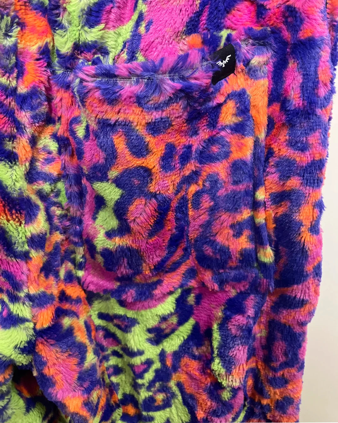 Close-up of a colorful, patterned leopard print sweatpant fabric with vibrant colors.