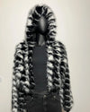 Mannequin wearing a black and white fake fur coat on a plain background