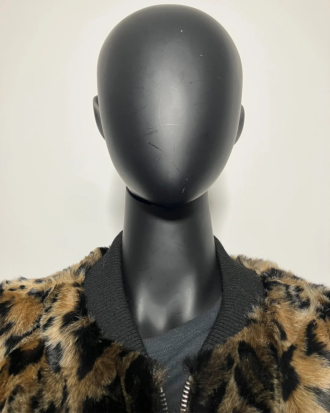 Mannequin wearing a leopard print jacket with a plain background