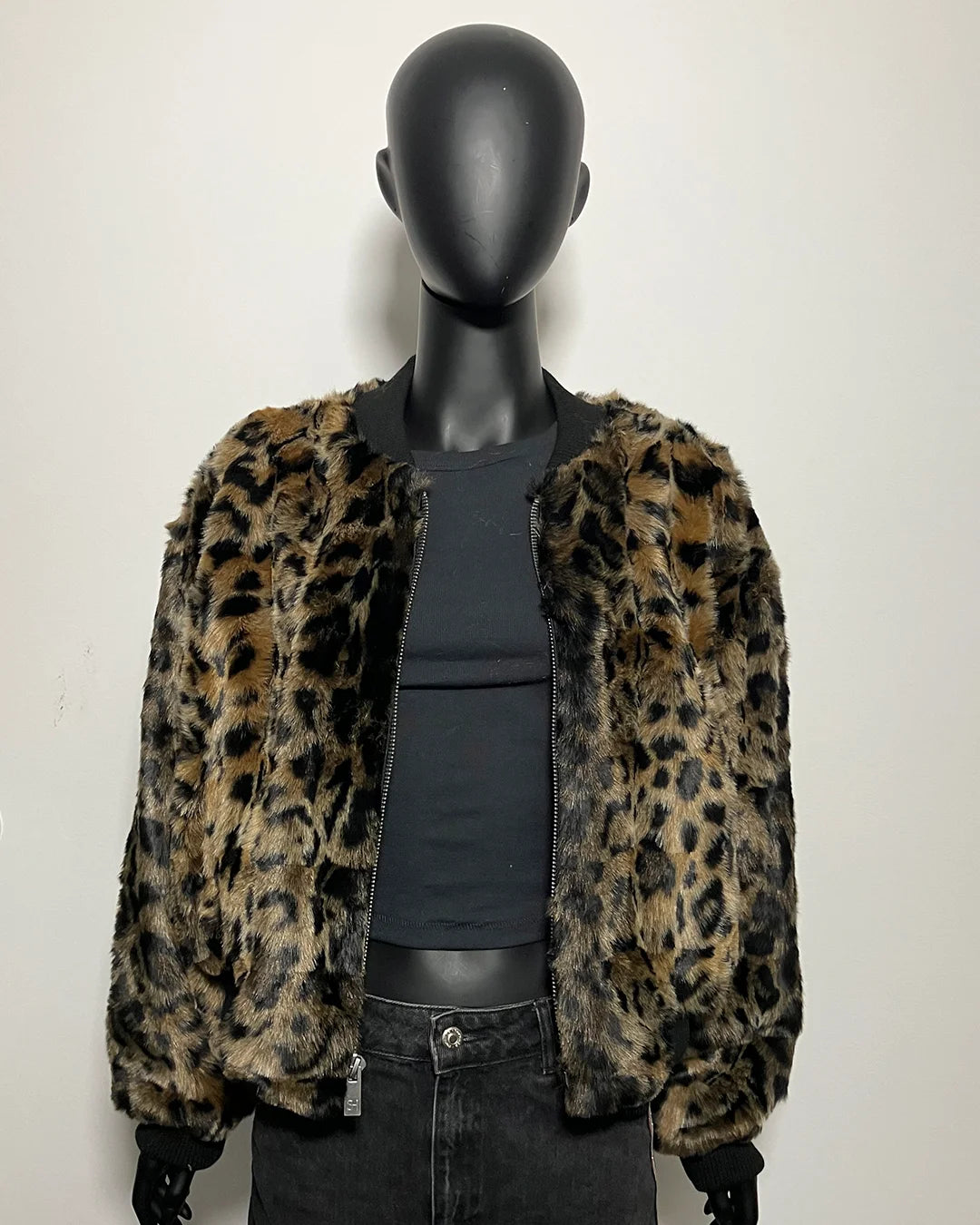 Mannequin wearing a leopard print jacket on a plain background