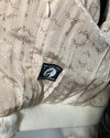 Textured fabric with a brand tag featuring a logo and text.
