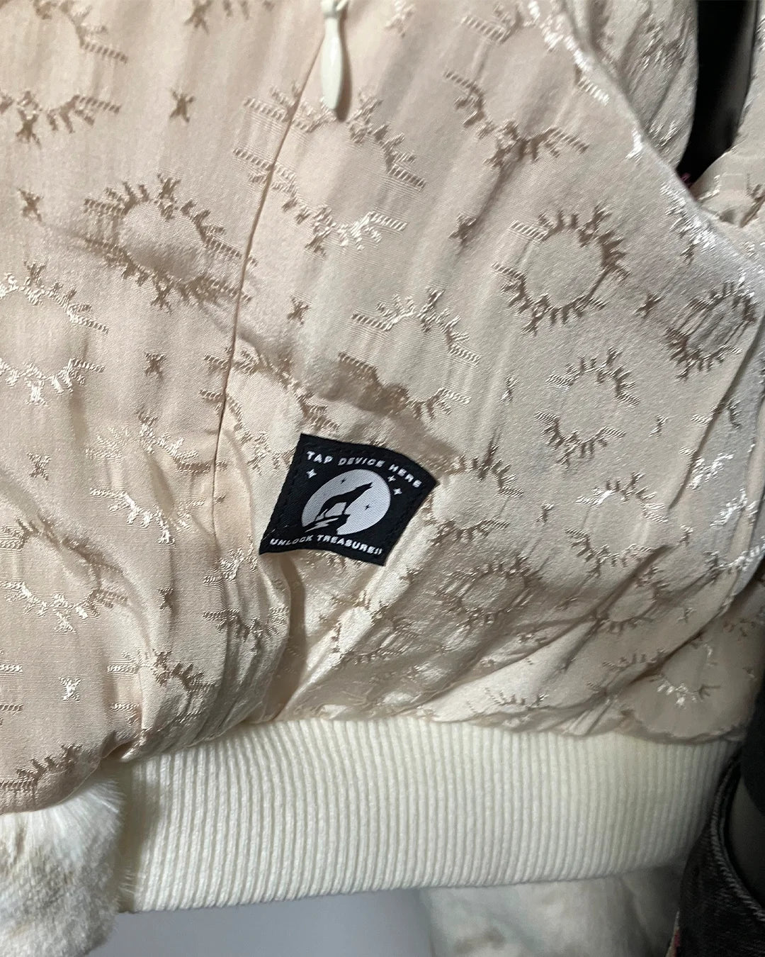 Textured fabric with a brand tag featuring a logo and text.