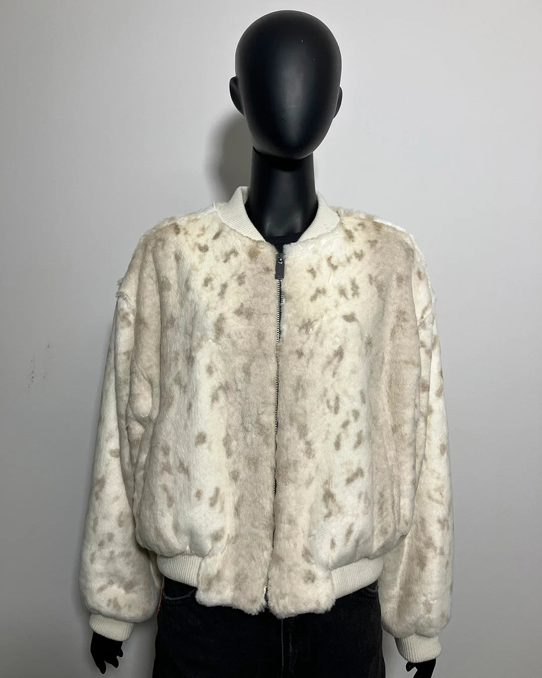White faux fr jacket on a mannequin against a plain background