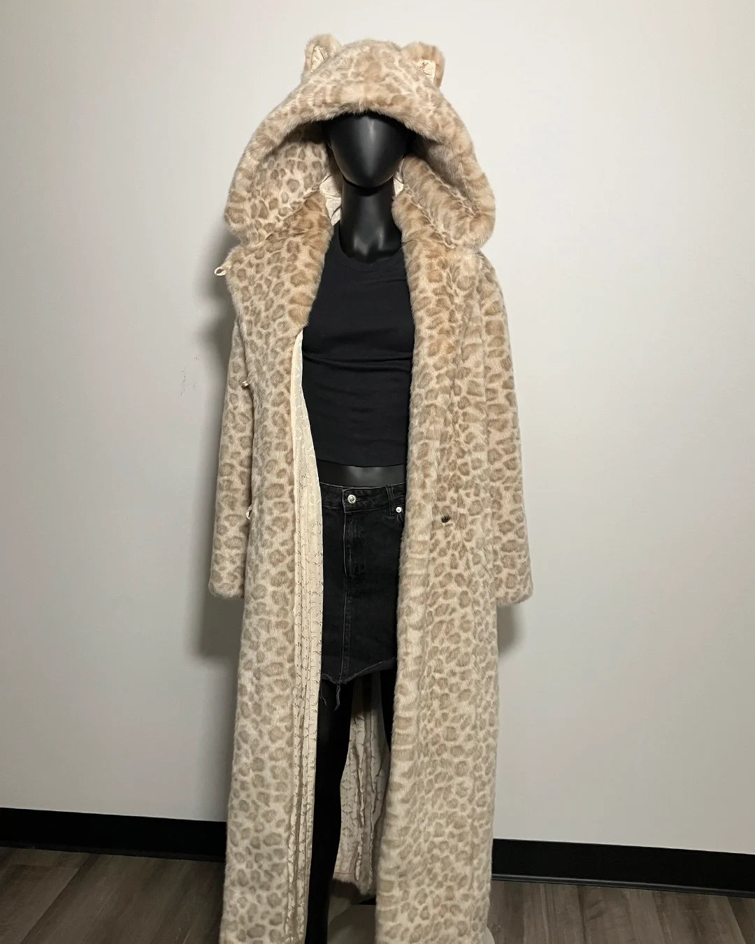 Leopard print coat on a mannequin against a plain background