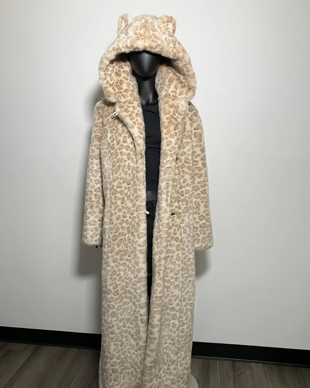 Leopard print coat on a mannequin against a plain background
