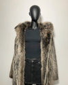 Mannequin wearing a fake fur coat and black outfit against a plain background