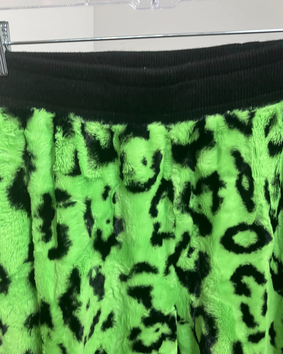 Green and black leopard print fabric on a hanger