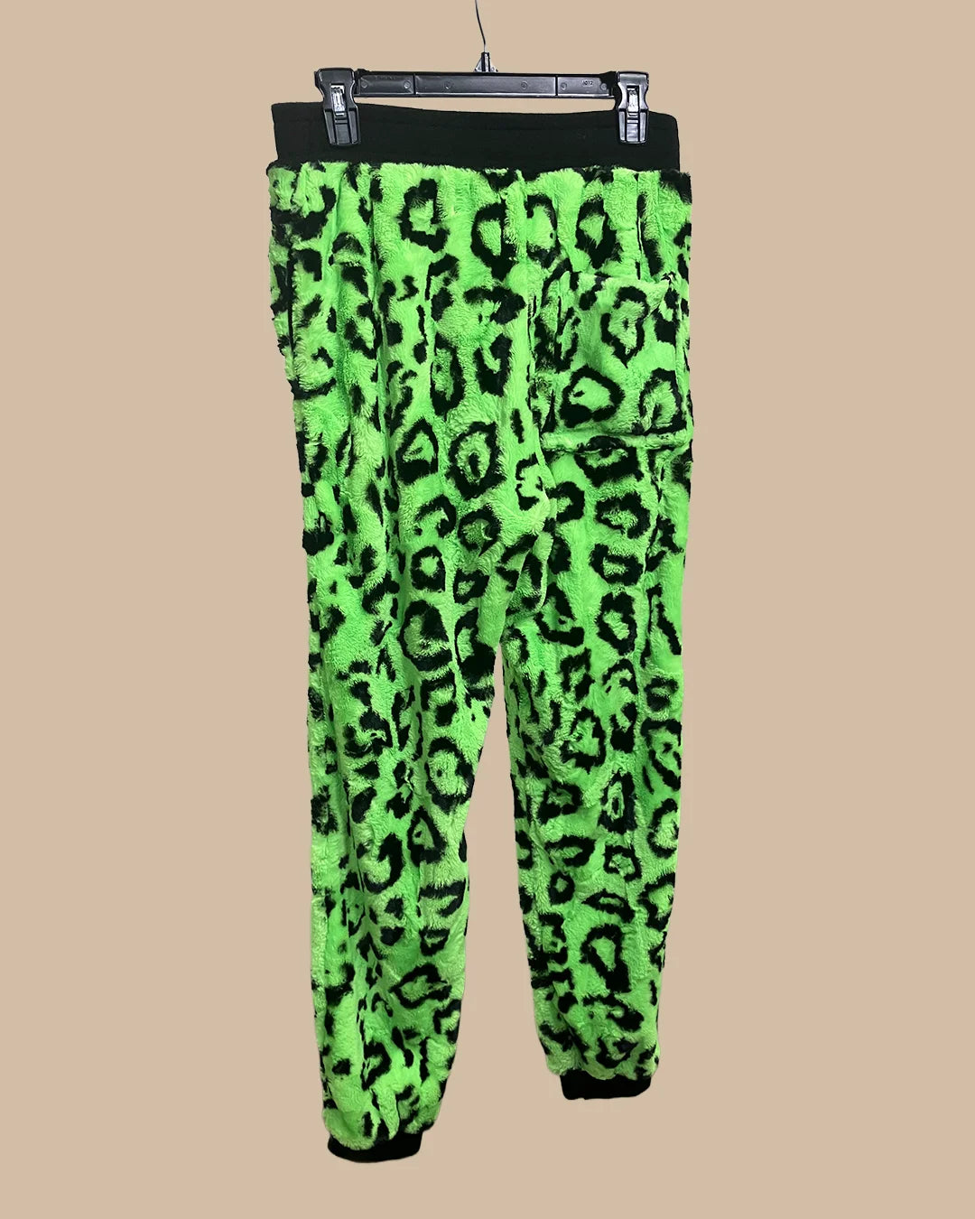 Neon green leopard print pants on a beige background