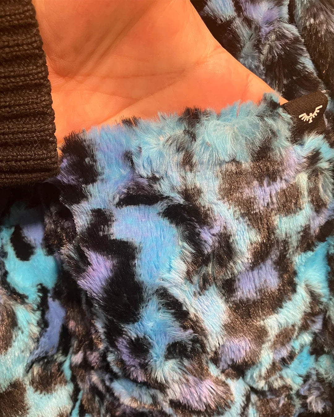 Close-up of textured fabric with multicolor  leopard print pattern in blues and violet