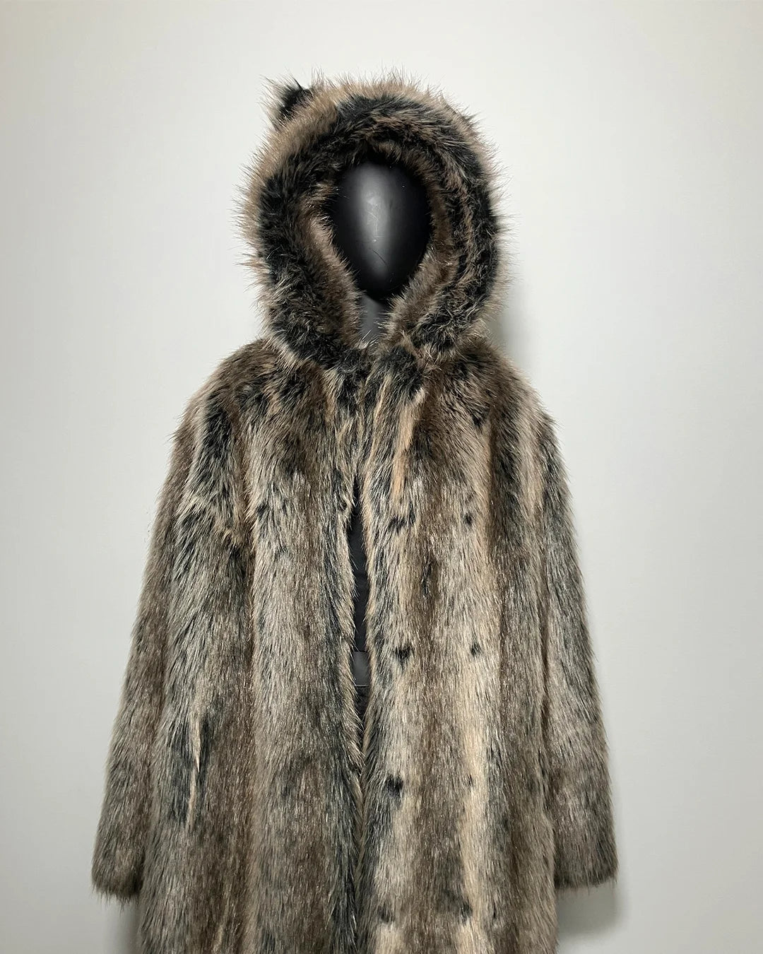 Fake Fur coat with hood on a mannequin against a plain background