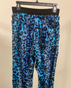 Blue leopard print sweatpants on a hanger against a beige background