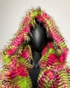 Mannequin wearing a colorful feathered coat with pink and green patterns on a plain background