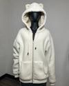 An off-white sherpa fleece zip-up hoodie with a hood featuring bear ears and a cream-colored lining, displayed on a black mannequin against a plain gray wall.