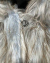 Close-up of a fluffy gray and white fake fur coat with a button.