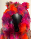 Mannequin wearing a colorful fake fur coat with a hood on a plain background