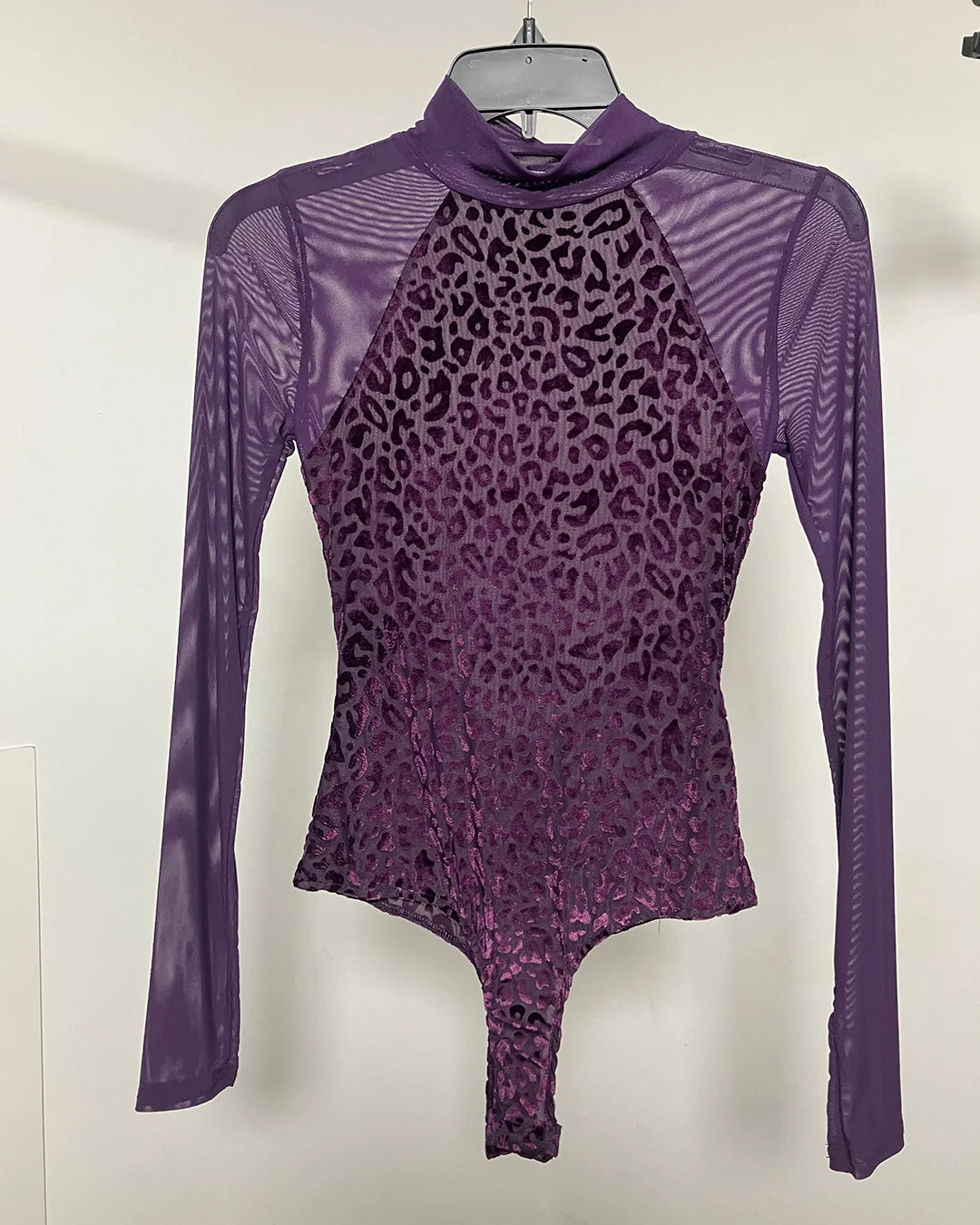 A purple long-sleeve bodysuit with a leopard print pattern on the torso and sheer mesh sleeves, hanging on a hanger against a plain light background.