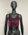 A sleeveless crop top with a metallic magenta and black leopard print pattern, displayed on a black mannequin torso.