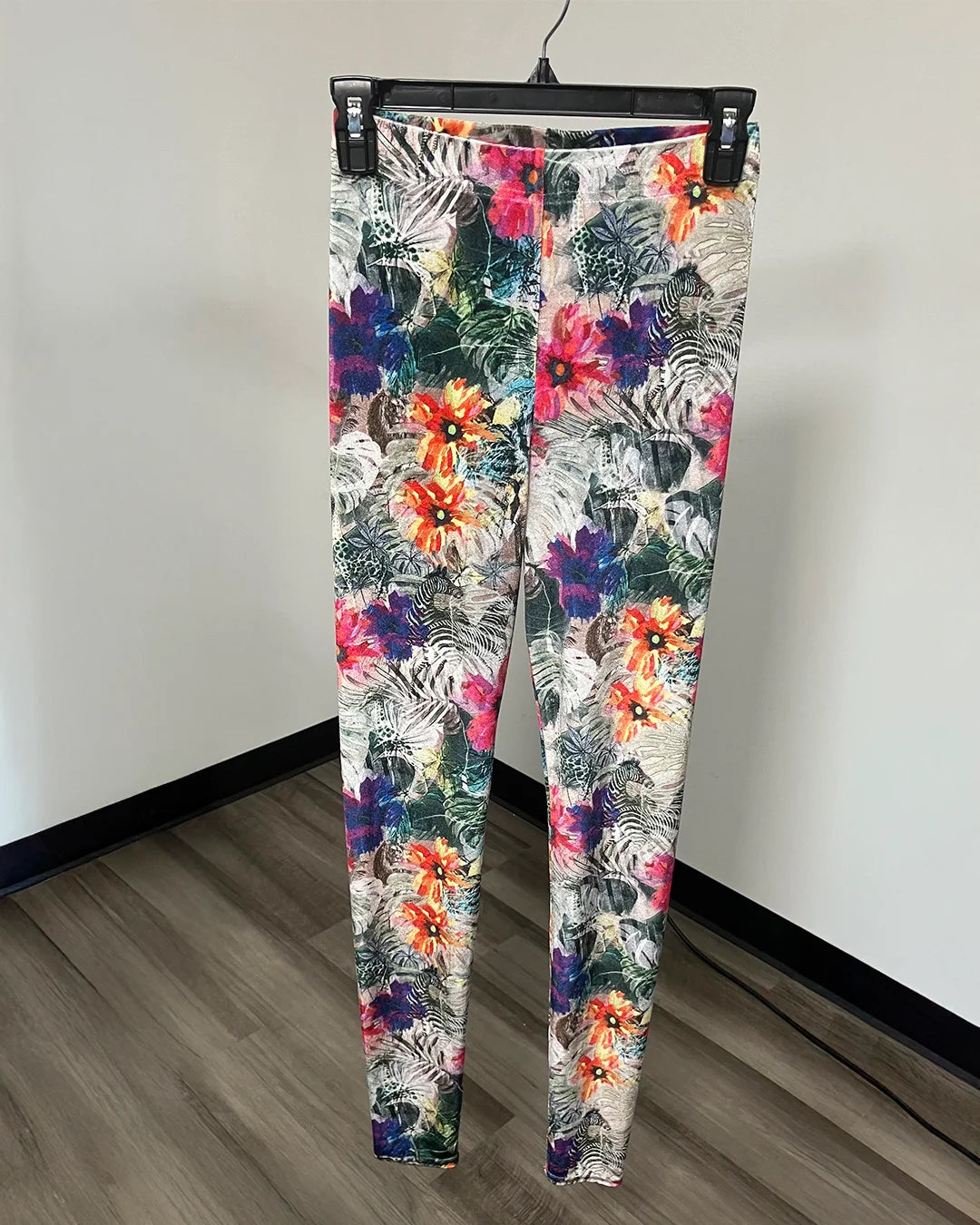 Floral pattern leggings on a black hanger.