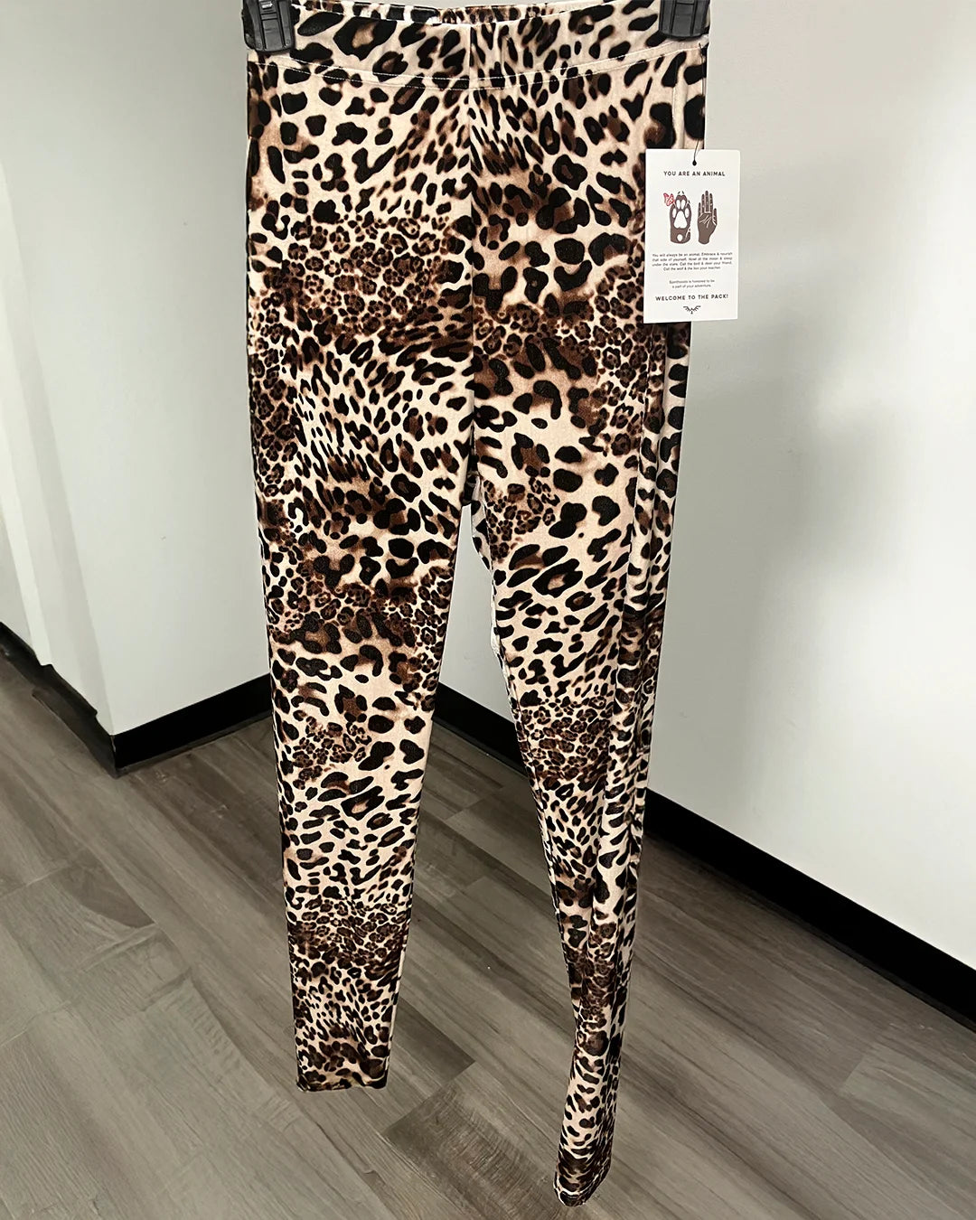 Leopard print leggings on a black hanger.