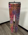 A pair of high-waisted leggings with a vibrant neon leopard print pattern, hanging on a black hanger against a plain wall.