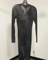 A long-sleeve black mesh jumpsuit with a textured, reptile-like pattern, hanging on a black hanger against a plain white wall.