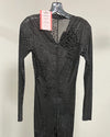 A black long-sleeve mesh dress with a textured, reptile-like pattern, hanging on a black hanger with a pink and white tag attached.