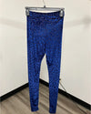 Blue leopard-print leggings hanging on a gray hanger against an off-white wall with a wood-look floor.